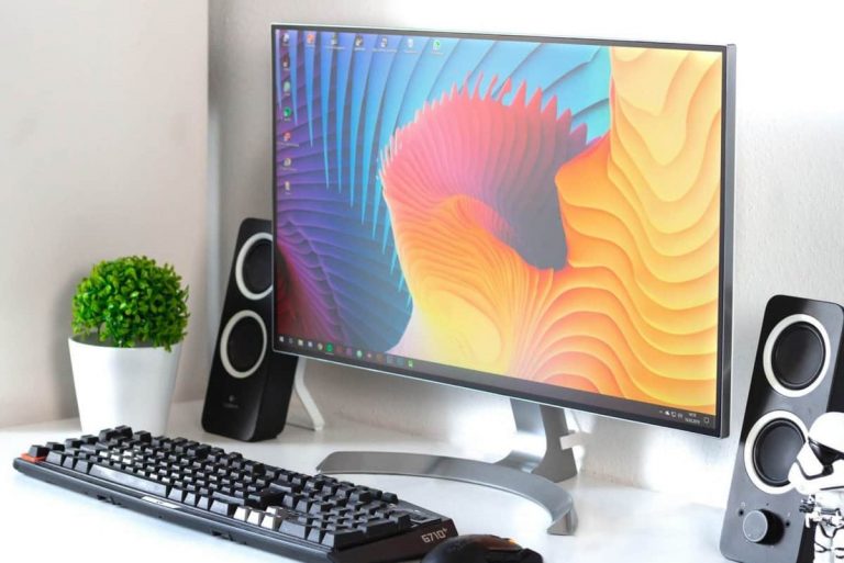 A clean gaming setup with a single 4k monitor and wireless mechanical keyboard